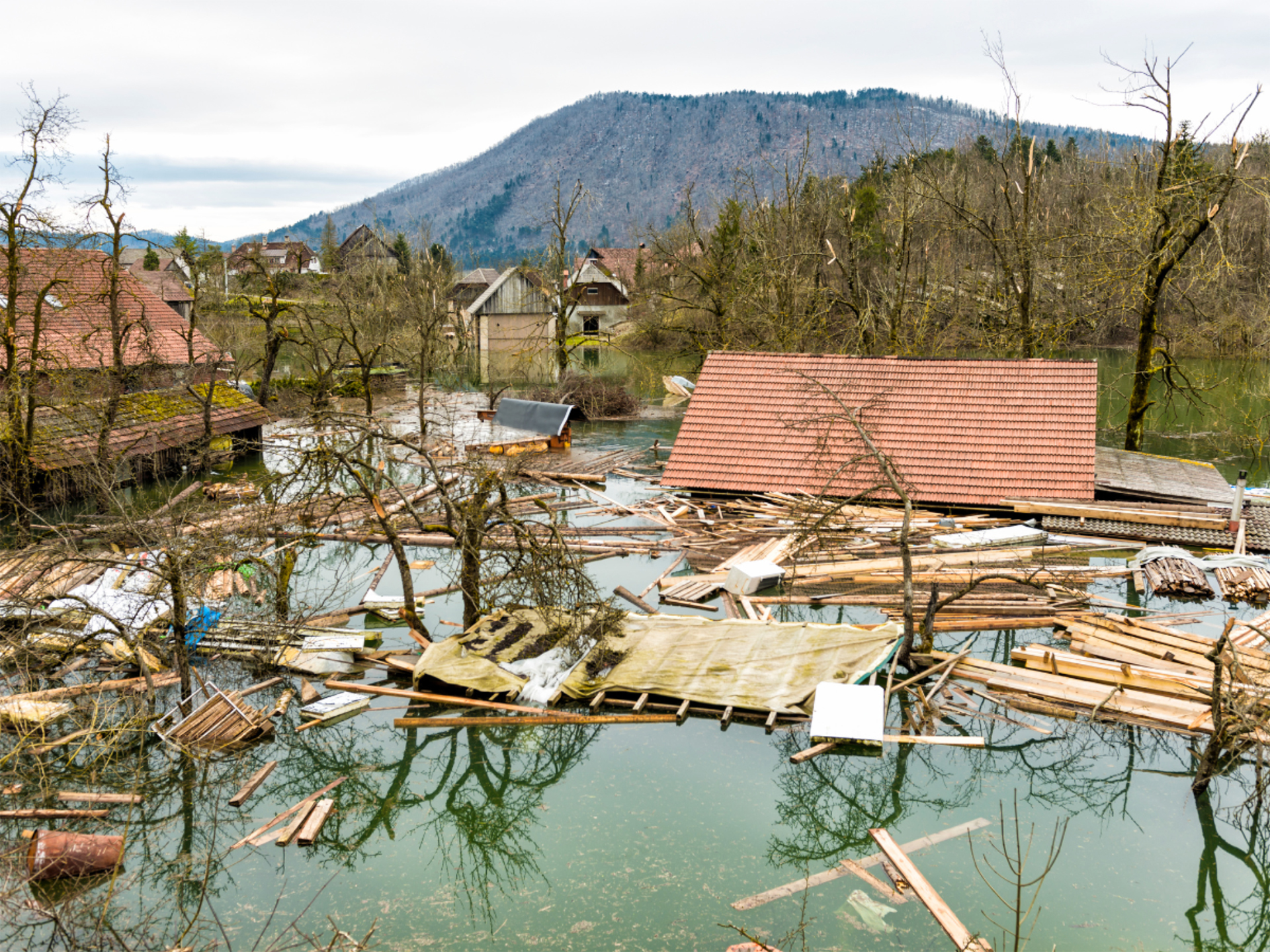 flooded mountainous town with lumber and debris floating