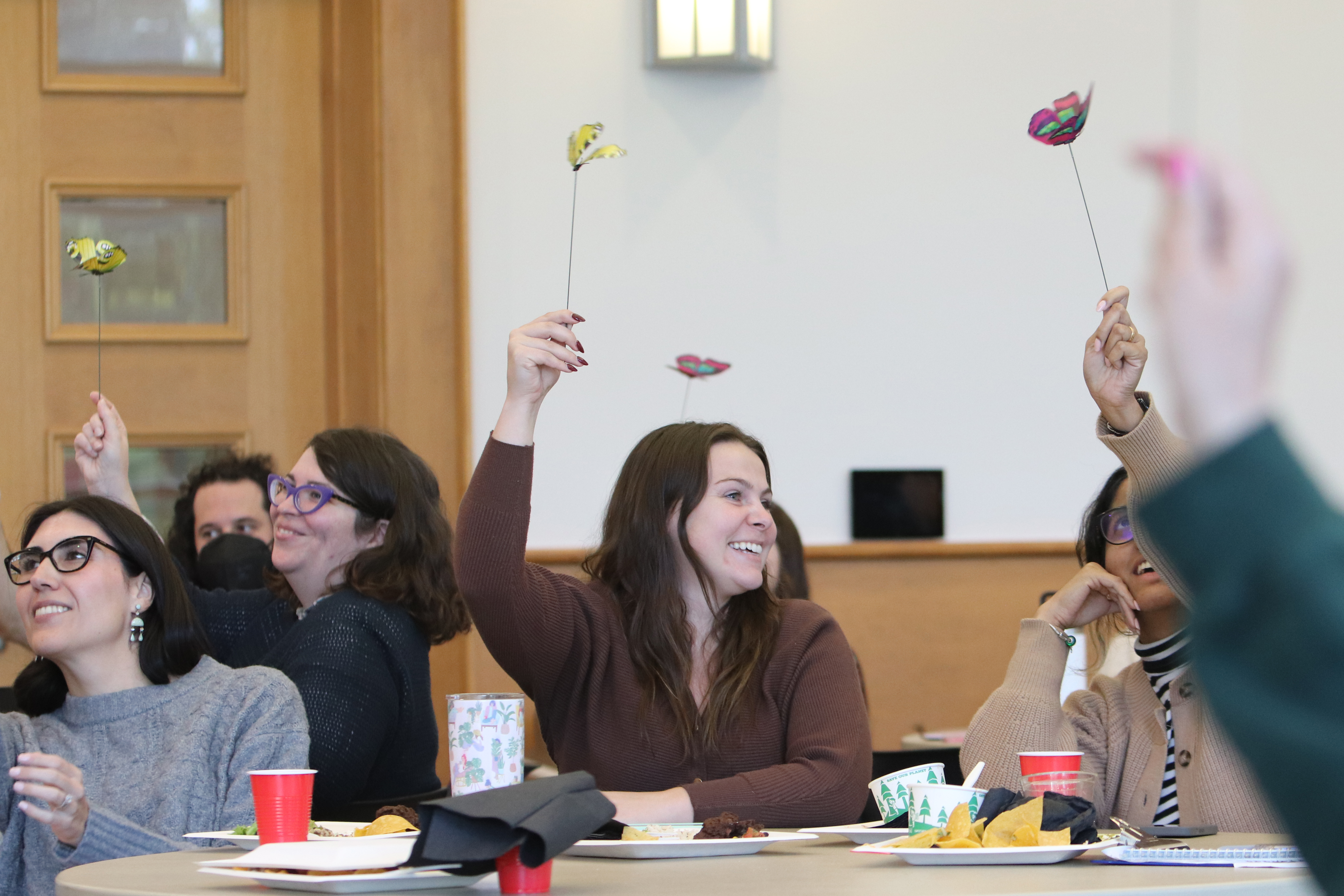 workshop participants hold wires topped with metal butterflies