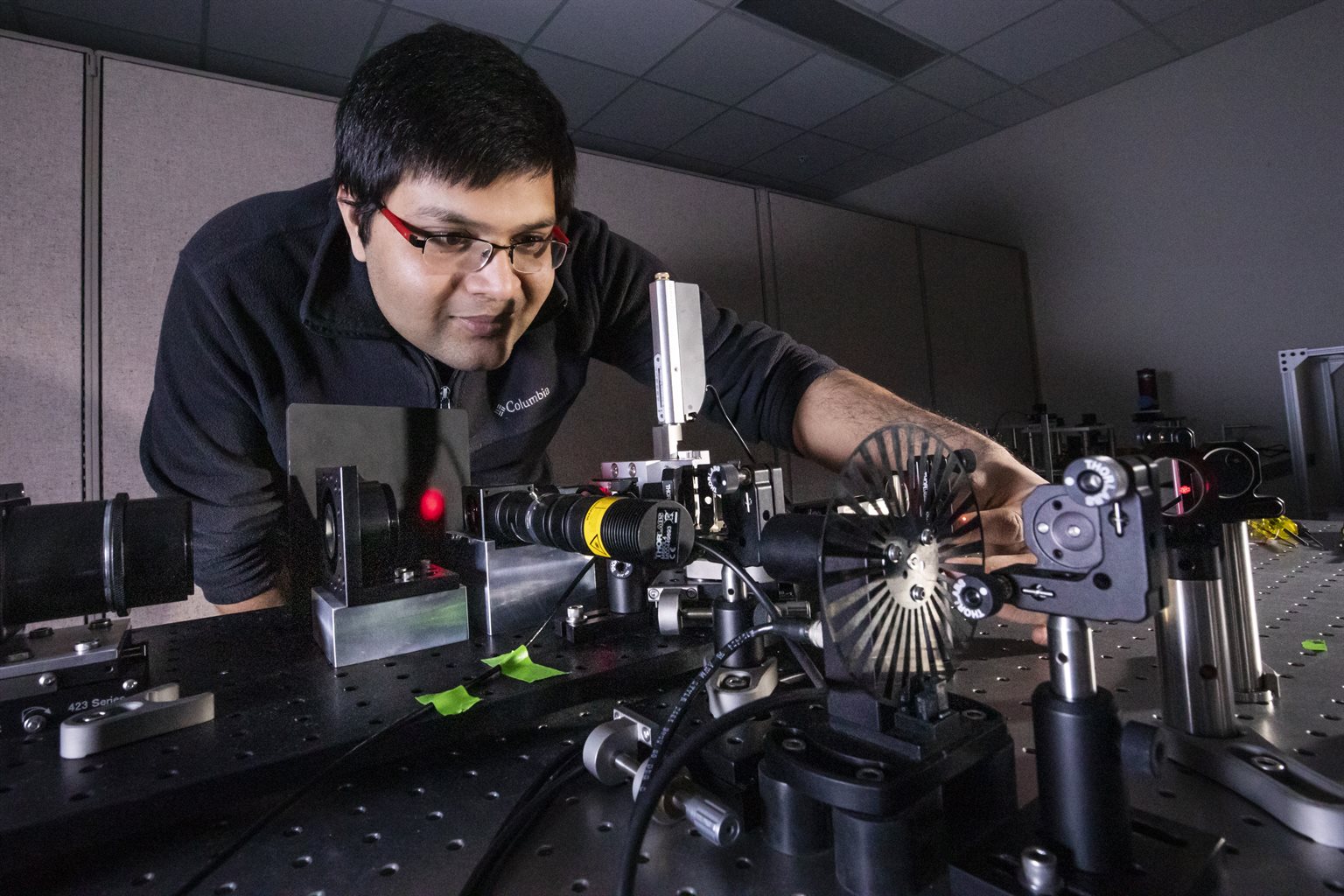 Male graduate student doing laser research at cancer center in Beckman Institute.