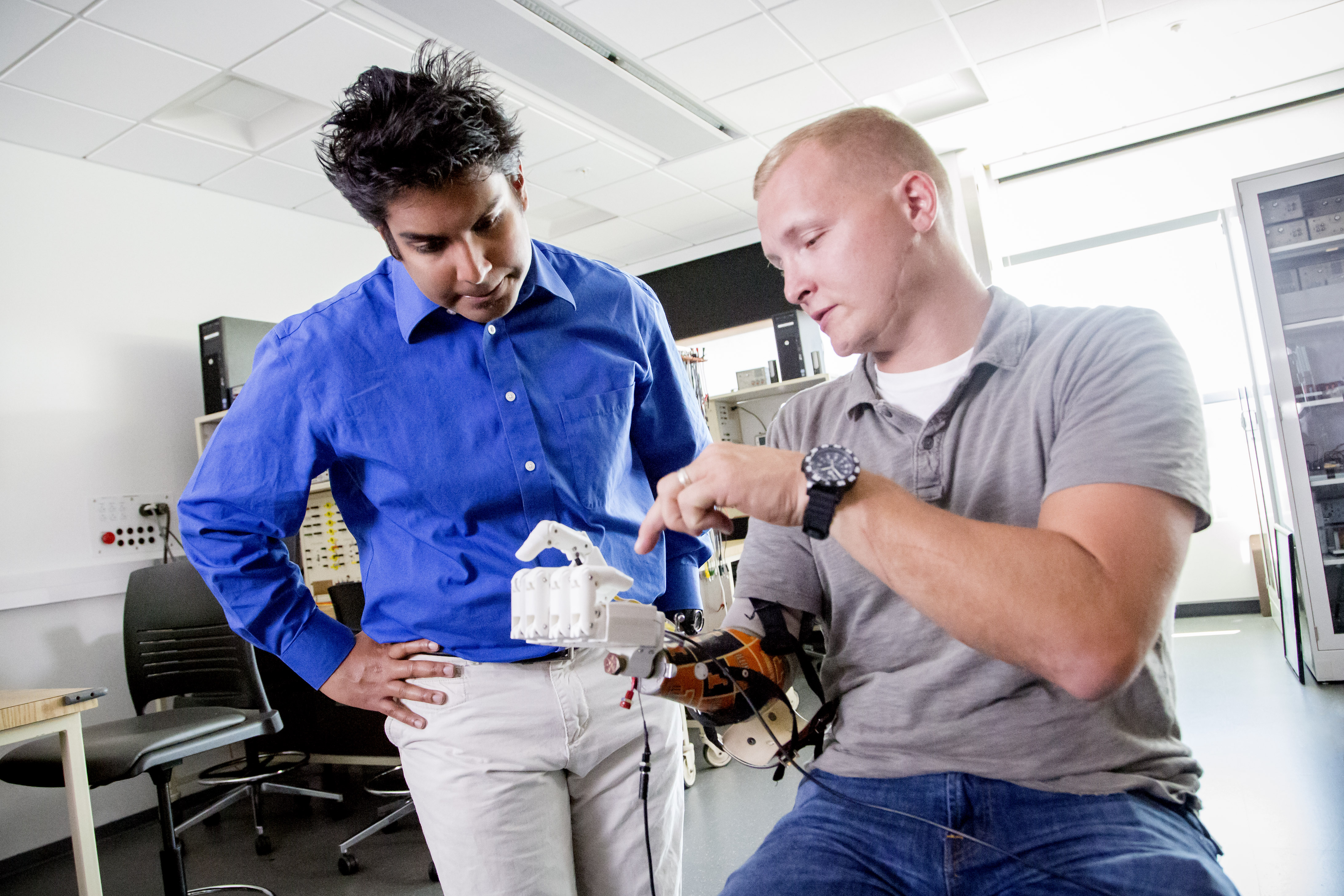 Graduate student with prosthetic arm and client.