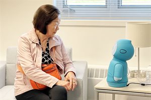 An older adult interacts with a social robot