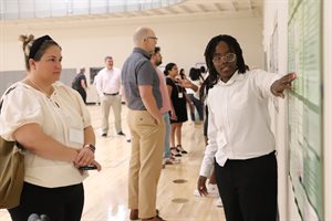 Kathure Kiunga, a 2024 Community-Academic Scholar, presents during the poster session at the Martens Center